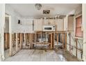 Incomplete kitchen remodeling with white tile floor and cabinets above microwave at 8706 Tahiti Ln, Tampa, FL 33615