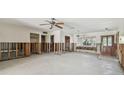 Empty living room featuring large window, ceiling fan, and front door at 8706 Tahiti Ln, Tampa, FL 33615