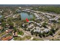 Aerial view showcases this neighborhood's well-maintained buildings near a serene lake and lush greenery at 9037 Pebble Creek Dr, Tampa, FL 33647