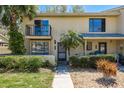 Charming townhouse with private balcony, tropical landscaping, and inviting entrance at 9037 Pebble Creek Dr, Tampa, FL 33647