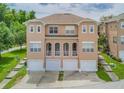 An aerial view of tan townhouses each featuring a garage and well manicured landscaping at 94 S Highland Ave # 2402, Tarpon Springs, FL 34689