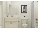 Bright bathroom with a single sink vanity, framed art, and shower with tub at 11853 Sparkling Topaz Cv, Parrish, FL 34219