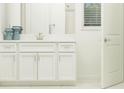 Bright bathroom featuring white cabinets, a large mirror, a modern sink, and a shower with white subway tile at 16969 Falling Waters Ct, Land O Lakes, FL 34638