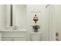 Bathroom showcasing white vanity, quartz countertop, faucet, and a mirror above a white toilet and shower at 16969 Falling Waters Ct, Land O Lakes, FL 34638