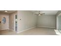 Open-concept living space showcasing neutral walls, tile floors, and seamless transition to the entryway and patio at 1721 Sutton Pl, Dunedin, FL 34698