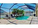 Sparkling screened-in pool with lush landscaping, a waterfall feature, and comfortable lounge seating at 2706 Colewood Ln, Dover, FL 33527