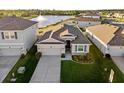 Aerial view of a single-Gathering home on a landscaped lot with a lake view and close proximity to neighboring homes at 3097 Storybrook Preserve Dr, Odessa, FL 33556