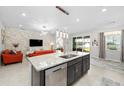 Modern kitchen island with granite countertops, stainless steel dishwasher and stylish pendant lighting at 3097 Storybrook Preserve Dr, Odessa, FL 33556