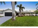 Well-maintained home featuring a lush lawn and a modern, painted driveway at 323 7Th N Ave, Tierra Verde, FL 33715