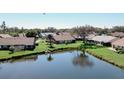 Water view of homes featuring a serene lake and lush green landscaping, creating a peaceful outdoor space at 440 Pendleton Dr, Venice, FL 34292