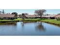 Scenic water view highlighting homes near a tranquil lake, reflecting the clear sky and surrounding greenery at 440 Pendleton Dr, Venice, FL 34292