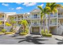 Inviting multi-story condo with a garage, balconies, lush tropical landscaping, and ample parking on a sunny day at 545 Bahia Beach Blvd, Ruskin, FL 33570