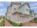 A bright two-story home featuring a brick driveway, two-car garage, and manicured landscaping at 5728 Skytop Dr, Lithia, FL 33547
