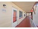 Condo hallway featuring unit door, outdoor walkway, and exterior architectural details at 5840 30Th S Ave # 305, Gulfport, FL 33707