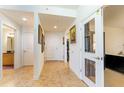 Long foyer with tan tile and white walls and doors to bathroom, bedroom and kitchen at 628 Cleveland St # 907, Clearwater, FL 33755