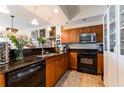 Cozy kitchen featuring granite countertops, dark appliances, and built-in display cabinets at 628 Cleveland St # 907, Clearwater, FL 33755