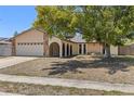 Inviting single-story home with stone accents, gated entry, manicured lawn, and attached two-car garage at 8329 Broken Willow Ln, Port Richey, FL 34668