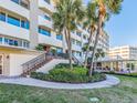 Exterior staircase to a building entry surrounded by tropical landscaping and palm trees at 100 Bluff View Dr # 317A, Belleair Bluffs, FL 33770