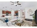 Open-concept living area with comfortable sectional sofa, modern ceiling fan, and seamless flow into the kitchen at 10105 Paradise Fish Dr, Riverview, FL 33578