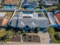 Aerial view of a home showcasing a screened pool, fenced yard, complemented by mature trees and landscaping at 1017 Jamaica Way, Tarpon Springs, FL 34689
