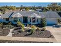 Attractive home features a well-kept lawn, lush plantings, neutral color palette, and a welcoming entrance at 1017 Jamaica Way, Tarpon Springs, FL 34689