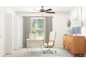 Bright home office boasts a modern desk, stylish decor, ceiling fan, and natural light from a nearby window at 10301 Gentle Rain Dr, Land O Lakes, FL 34638