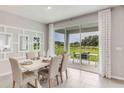Dining room featuring a white dining table, seating for six, and sliding glass doors to the patio at 10559 Farm Hill Ave, Land O Lakes, FL 34638