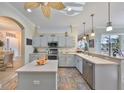 Charming kitchen with light cabinets, tile floors, stainless steel appliances, and ample counter space at 1123 Signature Dr, Sun City Center, FL 33573