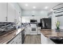 Well-lit kitchen with white cabinets, stainless steel appliances, and center island with seating at 14916 Rocky Ledge Dr, Tampa, FL 33625