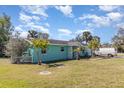 Charming one-story home with light blue exterior, green grass and palm trees at 311 Ravenna N St, Nokomis, FL 34275