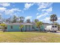 Charming one-story home with light blue exterior, green grass and palm trees at 311 Ravenna N St, Nokomis, FL 34275
