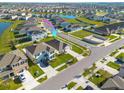 Expansive aerial view of a residential neighborhood with neatly arranged homes, community pond and green spaces at 31399 Penny Surf Loop, Wesley Chapel, FL 33545