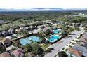 Aerial view of community pool, tennis courts, and neighborhood at 31730 Spoonflower Cir, Wesley Chapel, FL 33545
