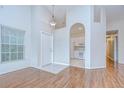 Inviting living room featuring vaulted ceilings and hardwood floors with natural light at 34907 Double Eagle Ct, Zephyrhills, FL 33541