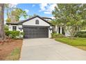 Well-maintained home featuring a landscaped yard, an attached two-car garage, and stylish black and white accents at 3709 W Horatio St, Tampa, FL 33609
