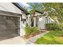 Landscaped front yard and covered entryway featuring contrasting black and white accents and a two-car garage at 3709 W Horatio St, Tampa, FL 33609