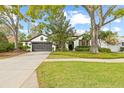 Attractive curb appeal featuring mature shade trees, lush landscaping, and a well-maintained lawn at 3709 W Horatio St, Tampa, FL 33609