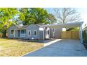 Side view of a light gray home, showing a covered parking area and manicured lawn at 3710 W Griflow St, Tampa, FL 33629