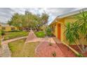 Inviting front yard with mature tree, walkway leading to front door, and manicured landscaping at 401 Dorchester Pl # 69, Sun City Center, FL 33573