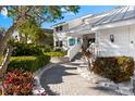 Charming walkway leading to the front door of this well-maintained home surrounded by mature landscaping at 517 Belle Isle Ave, Belleair Beach, FL 33786