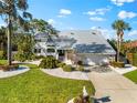 Stunning two-story home featuring a metal roof, lush landscaping, and a well-manicured lawn at 517 Belle Isle Ave, Belleair Beach, FL 33786