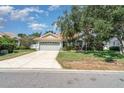 Charming single-story home featuring a well-maintained lawn, mature tree, and a two-car garage at 7581 Palmer Glen Cir, Sarasota, FL 34240