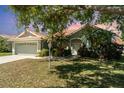 Charming single-story home with lovely lawn and landscaping, mature tree, and a two-car garage at 7581 Palmer Glen Cir, Sarasota, FL 34240