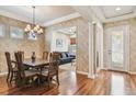 Formal dining area with decorative wallpaper, chandelier, and hardwood flooring at 14605 Chatsworth Manor Cir, Tampa, FL 33626