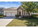 Beautiful single-story home with stone accents, a well-manicured lawn, and an inviting front entrance at 14605 Chatsworth Manor Cir, Tampa, FL 33626