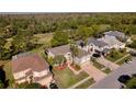 An aerial view of a home surrounded by lush greenery, a golf course and neighboring houses at 15618 Shoal Creek Pl, Odessa, FL 33556