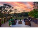 Inviting outdoor deck with stylish furniture, decorative lighting, and a beautiful treed view at 15618 Shoal Creek Pl, Odessa, FL 33556