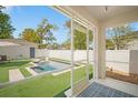 The screened-in lanai overlooks a private backyard oasis with modern pool and artificial grass at 216 N Habana Ave, Tampa, FL 33609