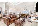 Open-concept living room with leather sofa, light wood floors, and a view of the kitchen and dining area at 2202 Yalta Ter, North Port, FL 34286