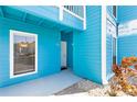 Inviting turquoise exterior with a covered entryway and well-maintained landscaping at 455 Alt 19 S Hwy # 81, Palm Harbor, FL 34683